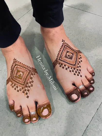 A modern and geometric foot mehendi for the Teej festival. The design features a central diamond shape with an elephant motif inside.