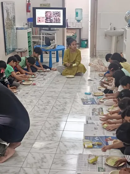 A parent volunteer leads a session on the architecture of Karnataka, teaching children about the state's rich history through its magnificent palaces and temples.