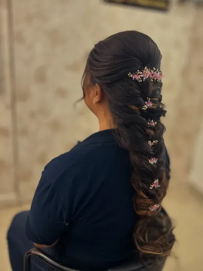 A variation of the mermaid braid, this time adorned with small pink floral pins for a softer, more romantic look.
