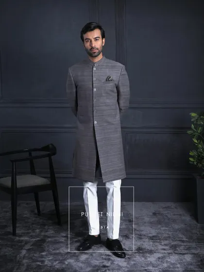 A regal expression in charcoal grey. This Matka silk achkan is paired with a paisley stole embroidered in tradition’s language. It is classic, royal, and timeless.