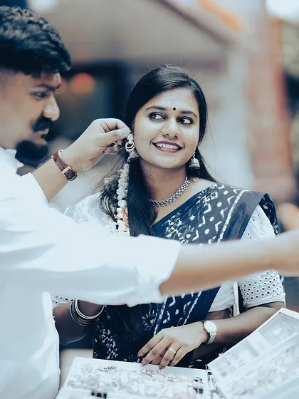 A candid street photography moment, with the groom helping the bride choose earrings from a street vendor in Bangalore.