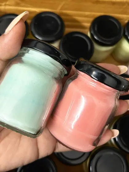 Holding a couple of mini scented candles in mint green and pink. I can create these in any color to match your baby shower theme.
