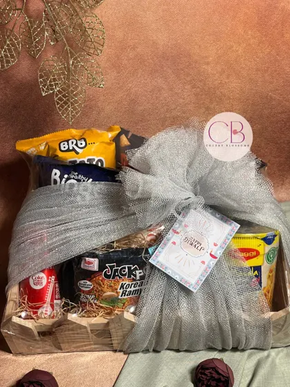 Spreading light and laughter this Diwali. This confectionery hamper is packed with a variety of snacks like Korean ramen, Binge chips, and Coca-Cola, all wrapped up in a beautiful pinewood tray.