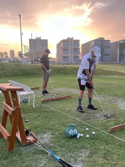 Players practicing their short game against the backdrop of a beautiful sunset. Our natural grass areas are perfect for honing all aspects of your game.