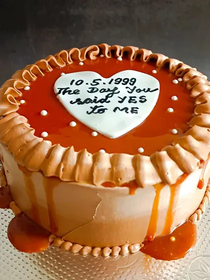 A rich coffee caramel cake with a sweet message, celebrating the day a couple said "yes".