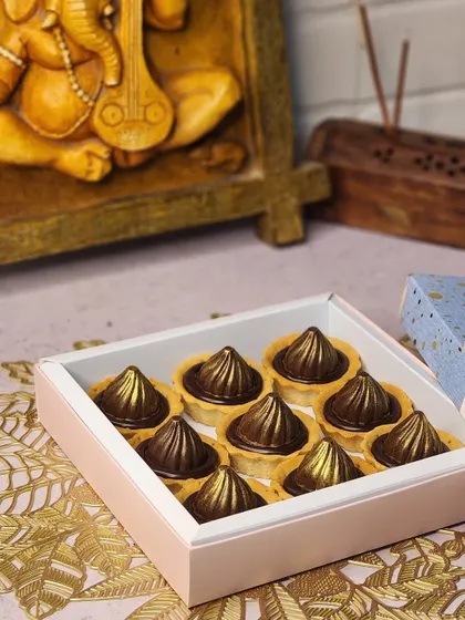 A box of nine of my signature chocolate modak tarts, ready for your Ganesh Chaturthi celebrations. The golden sheen on the chocolate makes them look as good as they taste.