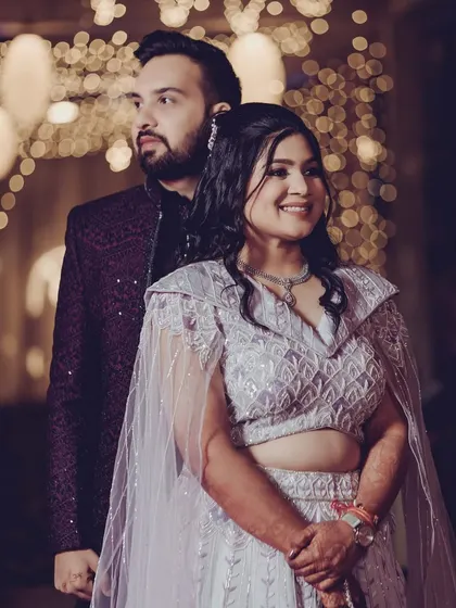 A beautiful portrait of the couple. Her makeup features a soft contour and defined eyes, complementing her modern caped lehenga for the sangeet.