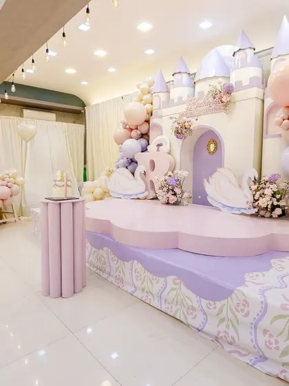 A side view of the princess castle stage, showing the custom-printed floor decal and the pink ball pit area.
