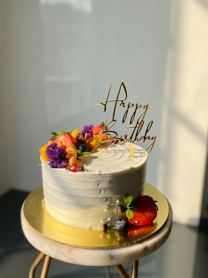 A beautiful shot of my Mixed Fruit cake, catching the sunlight. The combination of fresh strawberries, blueberries, mango, and edible flowers makes it so colorful.