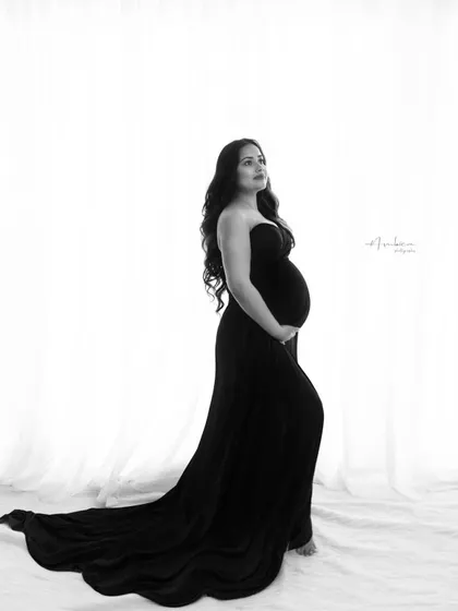 There is a timeless elegance in monochrome. This black and white studio portrait focuses purely on form, light, and emotion. The simple, classic composition highlights the beautiful curve of the baby bump, creating a powerful and intimate fine art maternity portrait.