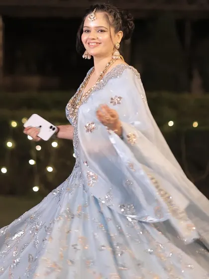 A guest twirling in a beautiful powder blue lehenga, her makeup looking fresh and radiant.