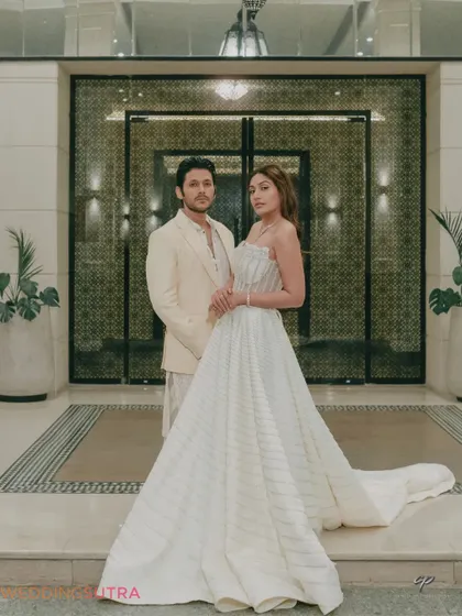 A grand and elegant portrait of the couple at the entrance of a luxury venue. This shot combines architectural beauty with the couple's sophisticated style for a truly regal pre-wedding photo.