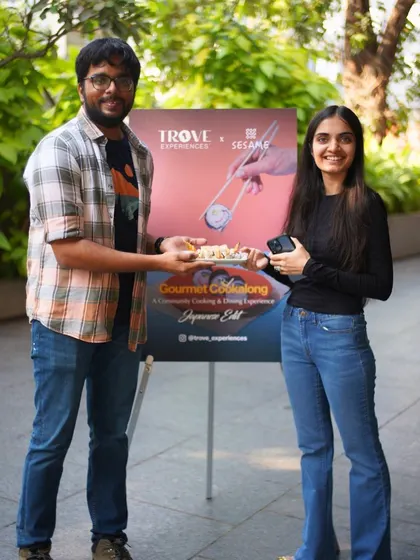 A happy couple poses by our event banner, holding the sushi they made. It’s a great memento of a fun and productive day.