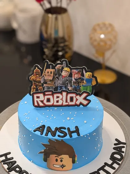 A simple and fun Roblox themed cake. This blue cake is topped with an edible logo and character toppers, perfect for a gaming fan's birthday.