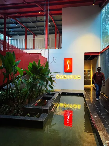 A person walks through the Saritha Serene office, highlighting the human scale of the space. The design is not just about form, but about the experience of moving through the building.