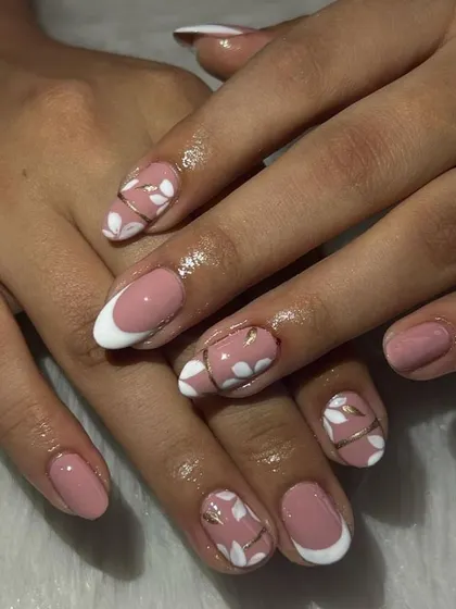 A sweet and simple design with a pink base, white French tips, and delicate, hand-painted white flowers with gold line details.
