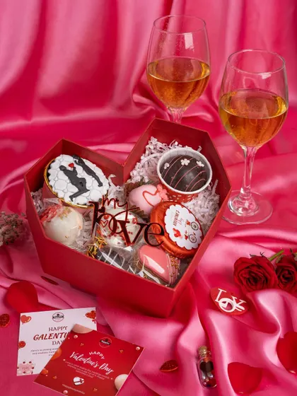 A romantic Valentine's Day hamper, styled with wine glasses on a pink satin cloth to create a feeling of love and indulgence.
