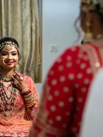 The bride looks at her reflection, a quiet and introspective moment captured before the wedding festivities begin.