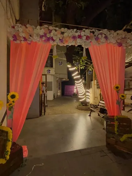 The entrance to the anniversary party, decorated with a matching floral arch and peach drapes to create a cohesive look throughout the venue.