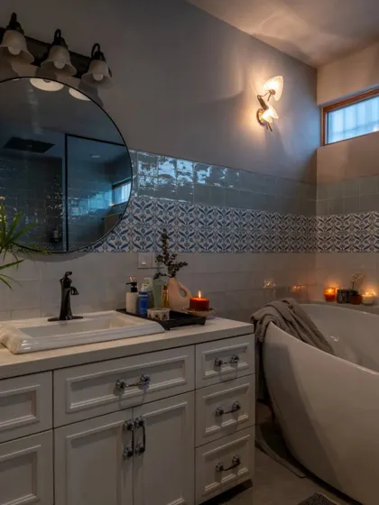 A serene bathroom in the Dhaka residence, where soft lighting and a freestanding tub create a peaceful atmosphere. The use of different tile patterns adds subtle detail and texture, making the space feel both luxurious and personal.