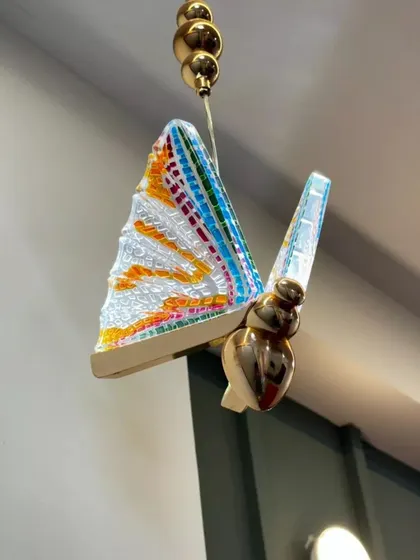 A close-up of a beautiful butterfly-shaped mosaic light fixture from a client's home, showcasing the unique and artistic details we incorporate into our designs.