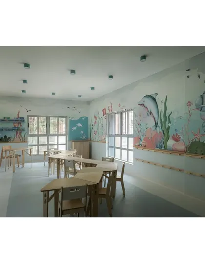 This view of the aqua classroom highlights the different zones for learning. The combination of open floor space and grouped tables allows for a variety of activities throughout the day.