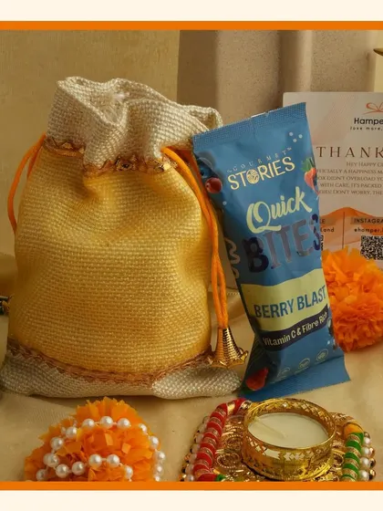 A simple and sweet festive gift. This orange potli bag contains healthy "Quick Bites" snacks, making it a great option for a small, thoughtful gesture during Diwali.