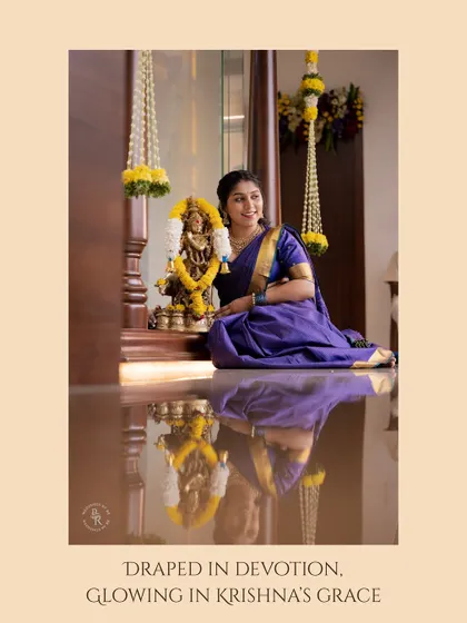 "Draped in devotion, glowing in Krishna's grace." A serene portrait of a woman by a Krishna idol, her reflection captured on the polished floor.