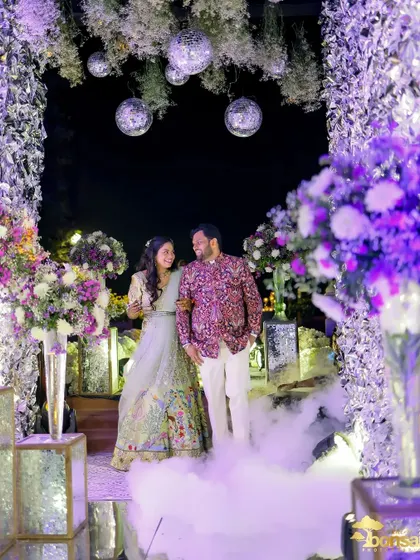The couple's grand entrance through a beautifully decorated archway with smoke effects.
