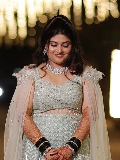A serene portrait amidst the festive lights. The makeup is soft and romantic, perfect for capturing the magical atmosphere of the Sangeet.