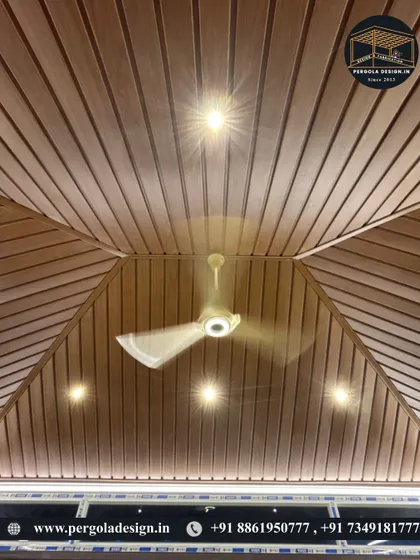The beauty is in the details. This upward view showcases the flawless finish of a wood-paneled PVC ceiling, complete with recessed lighting and a fan, ensuring comfort and elegance within the glass enclosure.