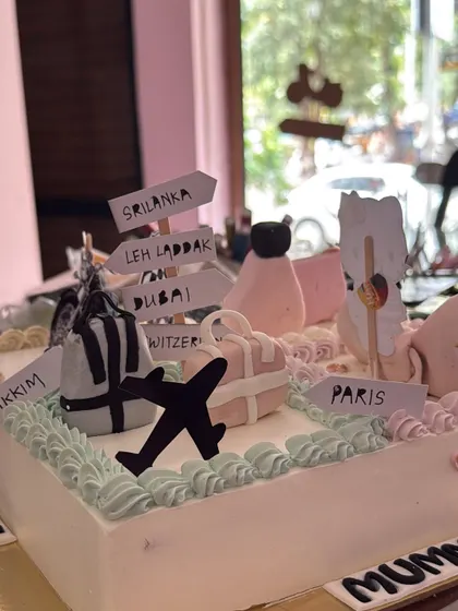 The travel-themed section of the cake, with signposts pointing to favorite destinations like Sri Lanka, Leh Ladakh, Dubai, and Paris.