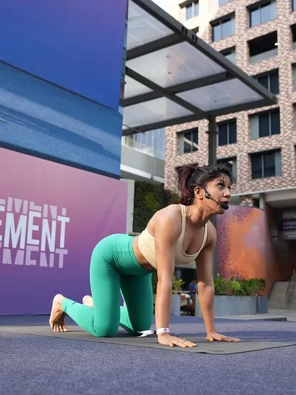 Demonstrating a quadruped position on stage. Clear, precise movements are essential when leading a large group, ensuring everyone can follow along safely.