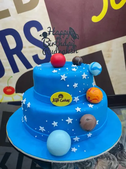 A 3kg two-tiered space cake in deep blue, decorated with stars and fondant planets.
