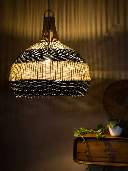 This two-tone pendant, featuring bands of black and white, is shown illuminated. The light glows warmly through the white section while being elegantly contained by the black, creating a striking visual balance.