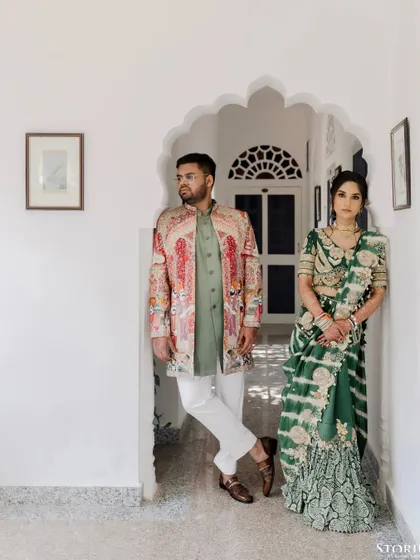 A stunning portrait of a couple in traditional attire, posing in a classic arched doorway at Alsisar Nahargarh, showcasing royal Rajasthani elegance.