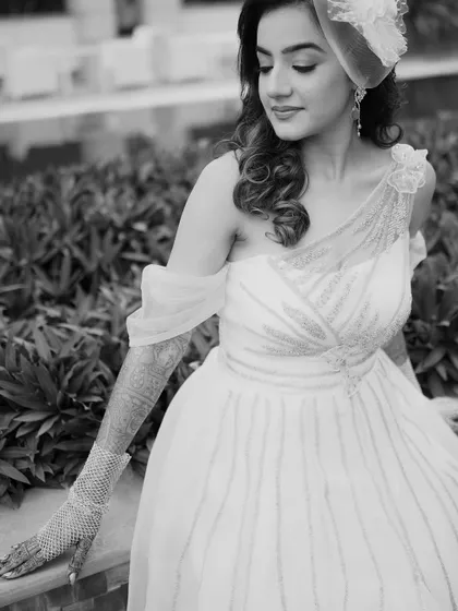 A classic black and white portrait of the bride. Her gentle expression and the soft light create a timeless and beautiful image, highlighting the details of her gown and henna.