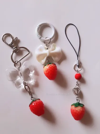 A trio of my strawberry-themed charms. I can make them as bag charms, phone charms, or keychains, each featuring a cute strawberry, bow, and butterfly.