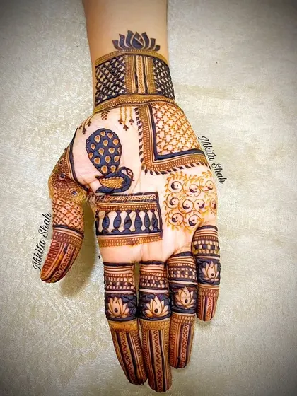 A trendy Indo-Western design with a patchwork feel. It combines different patterns like peacocks, checks, and florals in separate blocks for a very modern look.