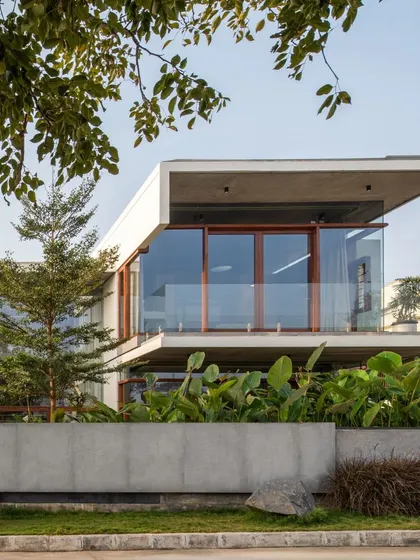 The Quarry House, where cuboidal concrete forms are softened by lush tropical planting and warm timber accents.