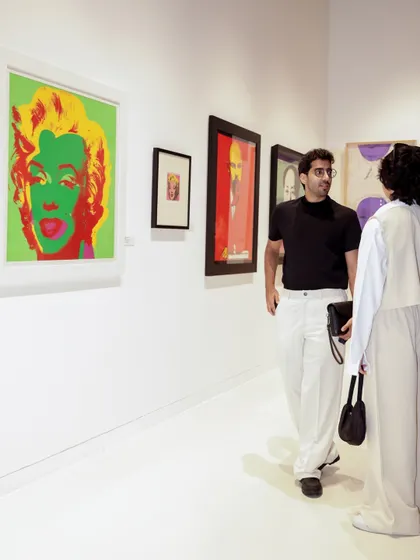 Guests admiring a Marilyn Monroe print by Andy Warhol. My music curation for art events aims to complement the art without overpowering it, enhancing the overall experience.