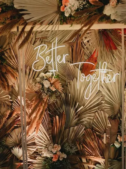 A whimsical swing photo-op set against a textured wall of dried palm leaves. This interactive element was a huge hit and added a fun, bohemian touch to the engagement party.