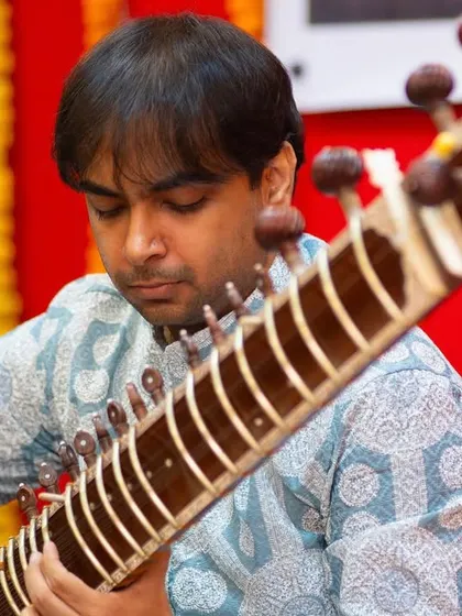 A close-up shot from a morning concert, capturing the focus and emotion I put into my playing. The details of the sitar and my hand movements are clearly visible.