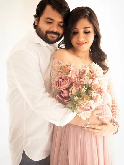 A warm and intimate embrace. This photo captures the protective and loving bond between the couple, with the dad-to-be holding her close.
