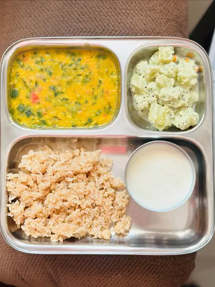 A light meal of broken wheat, dal palak, sautéed potato with poppy seeds, and a side of curd.