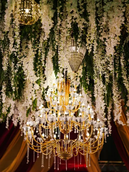 A close-up of the massive floral and crystal chandelier that served as the centerpiece for a grand reception.