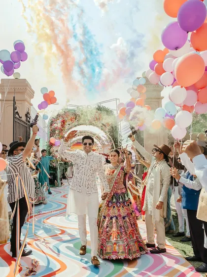 A grand and colorful entry with balloons and smoke bombs, capturing the festive spirit of the event.