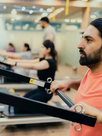 This client demonstrates focus and strength while performing a rowing exercise on the Reformer, which engages the back, arms, and core.