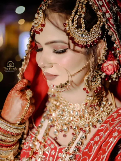 A beautiful and serene close-up of the bride. This shot highlights her flawless makeup and the delicate details of her bridal jewelry.