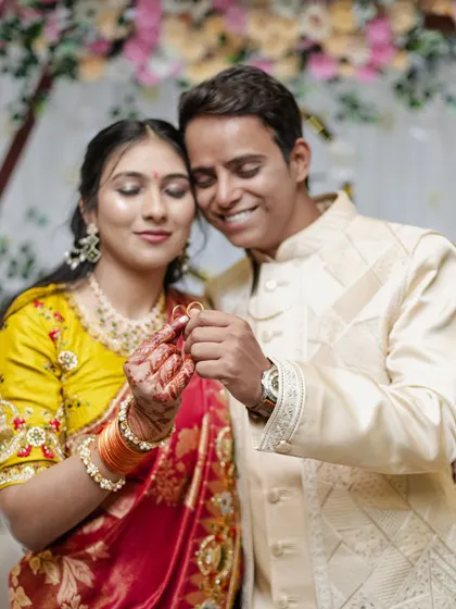 A happy couple holding up their engagement rings together after the ceremony.